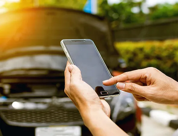 A person holding a phone, urgently calling for roadside assistance, symbolizing fast and dependable emergency support.