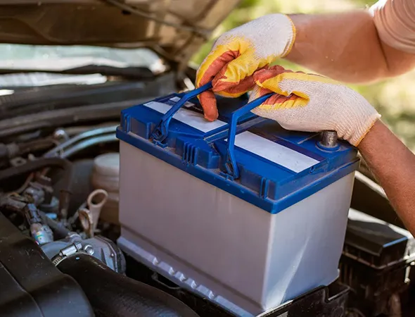 A professional technician installing a new car battery on-site, providing quick and dependable mobile battery replacement service.